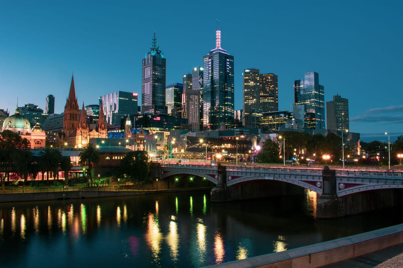 The Melbourne skyline at dusk, lit up above the Yarra River and Princes Bridge